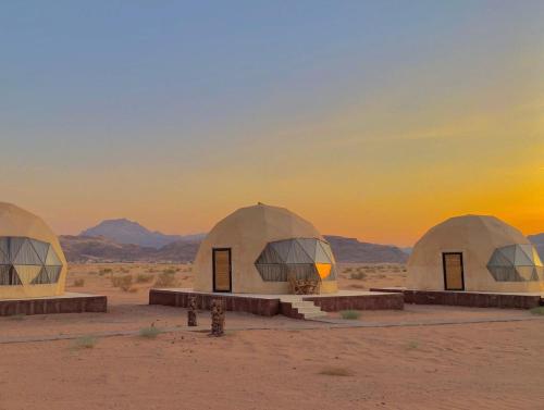 a group of domes in the desert at sunset at Wadi Rum Bubbles Wissam camp in Wadi Rum