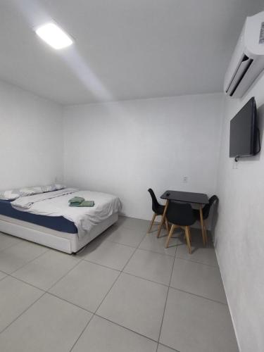 Loft Serra Gaúcha-Bem estar no coração de Nova Petrópolis في نوفا بتروبوليس: غرفة نوم صغيرة مع سرير وطاولة