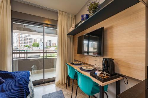 una camera d'albergo con scrivania e una camera con finestra di Edificio Hauz Mitre Vila Clementino a San Paolo