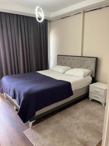 a bedroom with a large bed with a purple blanket at mersin merkezde her yere kolay ulaşım #daire in Mersin