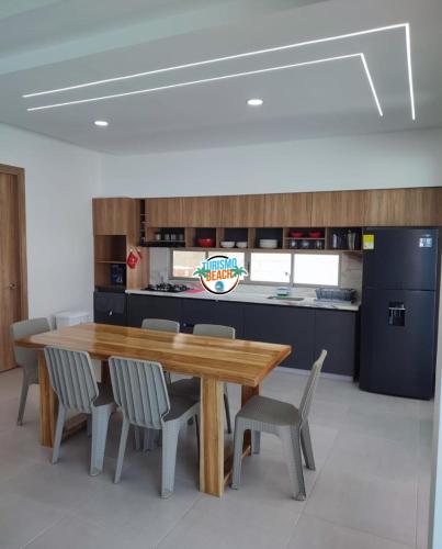 a dining room with a wooden table and chairs at Sun Beach in Puerto Colombia