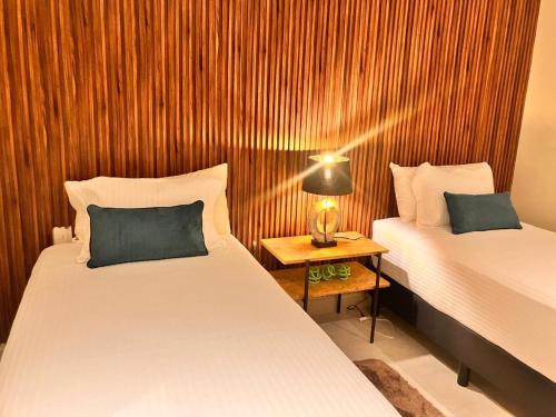 a room with two beds and a table with a lamp at Casa Cielo V-Bucerias in Bucerías