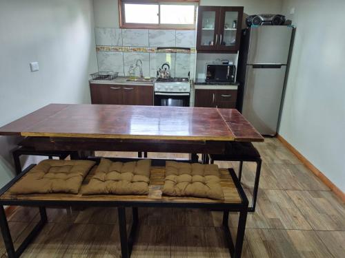 Cabaña Familia في شيلان: مطبخ مع طاولة خشبية وطاولة وثلاجة