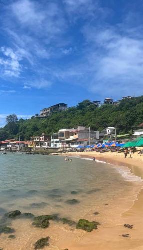 a beach with a group of people in the water at Pousada Castelo do Gaúcho in Baía Formosa