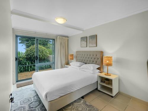 2-Bed Townhouse with Outdoor Area في Long Beach: غرفة نوم بيضاء مع سرير ونافذة