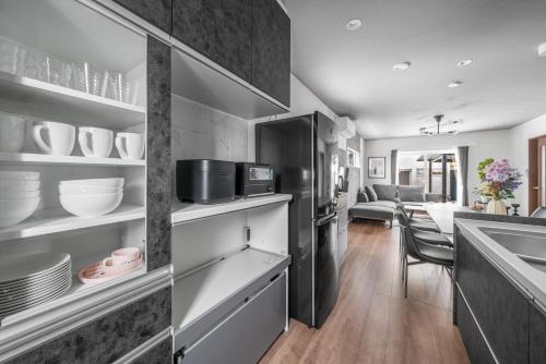 a kitchen with a black refrigerator and a table at Pregio Asahikawa in Asahikawa