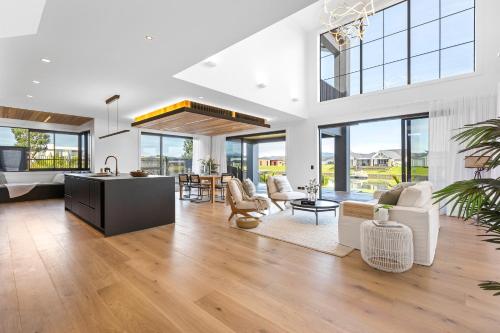 a living room with white furniture and large windows at Luxury Beach Retreat - Mountain Views & Boat Jetty in Whitianga