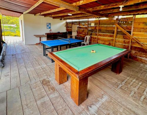 two ping pong tables in a room with wooden walls at Cabaña Sol in Calimita