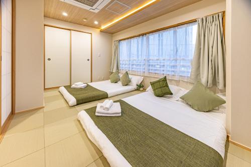 two beds in a room with a large window at New mansion 7 mins from Yoyogi stations in Tokyo
