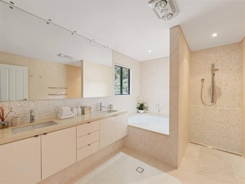 Un baño con bañera, lavabo y ducha. en Ocean Views - Refined Hilltop Residence by the Sea, en Yallingup