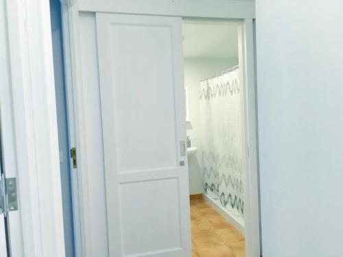eine weiße Tür in einem Raum mit einem Spiegel in der Unterkunft Amelia Cancajos - Confort Piscina y Playa cerca in Breña Baja