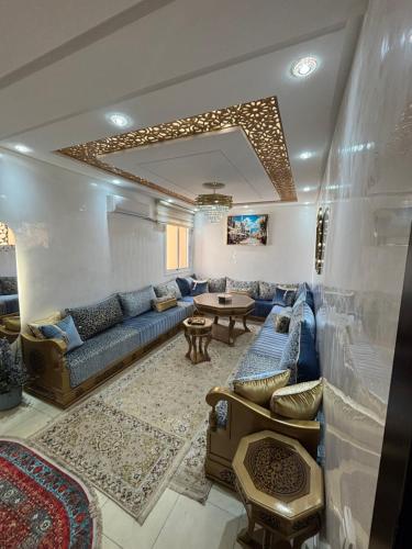 a living room with a blue couch and a table at Appartement traditionnel très moderne in Marrakech