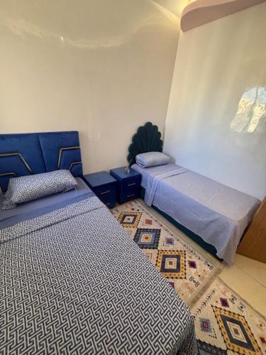 a bedroom with two beds and a rug at Appartement traditionnel très moderne in Marrakech