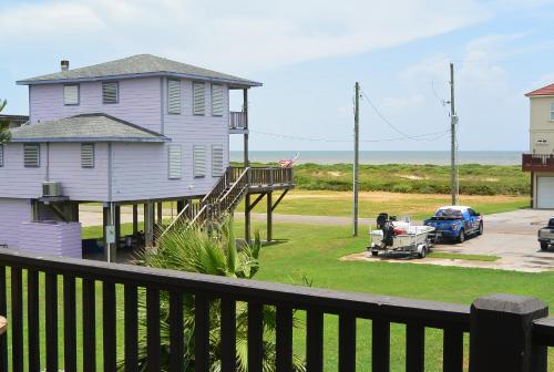 una casa con un camion parcheggiato di fronte all'oceano di The Sandy Cork Home a Bolivar Beach