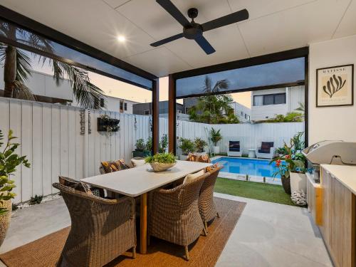 a dining room with a table and chairs and a ceiling fan at 3 Bed Coastal Escape, Pool, 1 Minute walk to Beach in Kingscliff