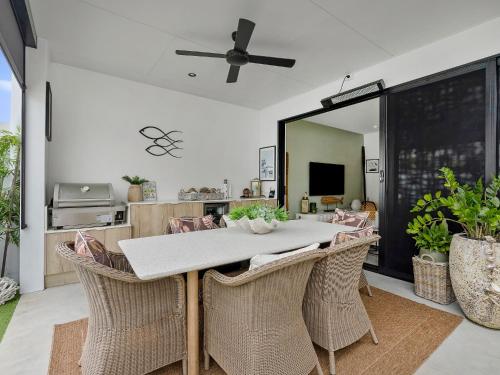 a dining room with a table with wicker chairs at 3 Bed Coastal Escape, Pool, 1 Minute walk to Beach in Kingscliff