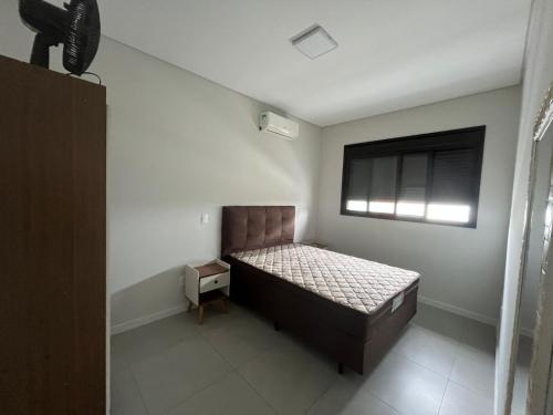 a bedroom with a bed and a window at Queridinho da praia de palmas in Governador Celso Ramos