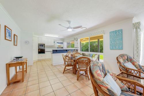 a kitchen and dining room with a table and chairs at 22 Bussey Street in Bargara