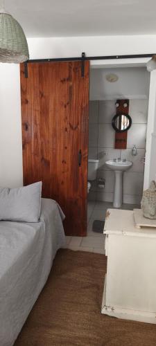 a bedroom with a bed and a bathroom with a sink at Casa Rio in Cruz del Eje