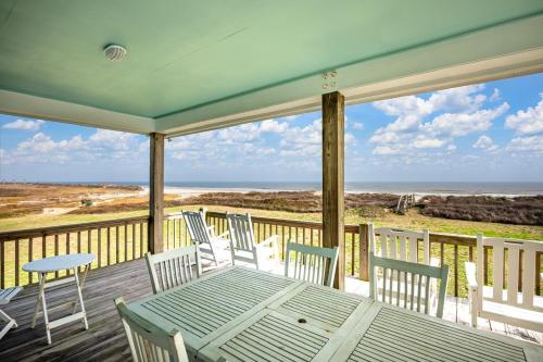 un portico con tavolo, sedie e vista sull'oceano di Lotz A View Home a Bolivar Beach