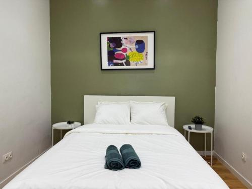 98 Apparthotel - Botanique 2 في لييج: سرير ابيض عليه حذان