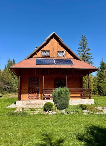 a log cabin with solar panels on the roof at Chata MOBY in Važec
