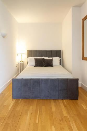 a large bed in a room with a wooden floor at The Central Suite in Manchester