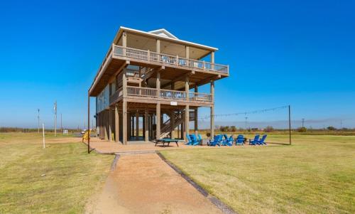 a large wooden building with blue chairs in a field at Deja Blue home in Caplen