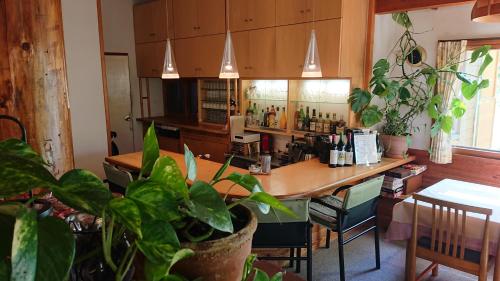 a kitchen with a table and a bar with plants at Pension Noel in Kaminoyama