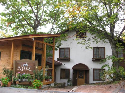 a house with a sign in front of it at Pension Noel in Kaminoyama