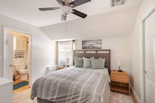 a bedroom with a bed with a ceiling fan at Sandy Pines Perch - Your Indian River Dock Life Base Camp in Sebastian