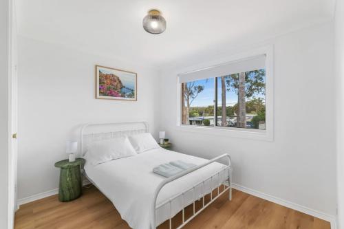 Erowal BayにあるThe Pearl A Fresh, Modern Family Retreat in Old Erowal Bayのベッドと窓のある白い寝室