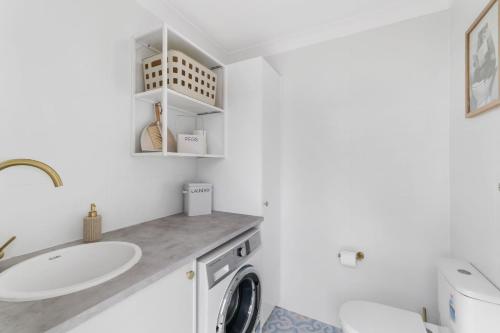 Erowal BayにあるThe Pearl A Fresh, Modern Family Retreat in Old Erowal Bayの洗面台と洗濯機を備えたバスルーム