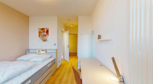 ユナングにあるRiver Residenz Basel&Huningueの白いベッドルーム(ベッド1台、テーブル付)