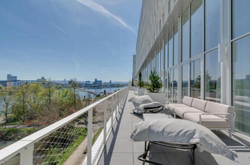 a balcony with couches and chairs on a building at River Residenz Basel&Huningue in Huningue