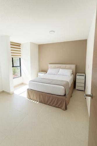 ein Schlafzimmer mit einem großen Bett und einem Fenster in der Unterkunft SextoMaíz in Morelia