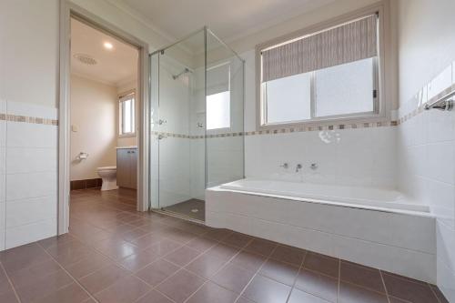 101 Padman Crs, Middleton في ميدلتون: حمام مع حوض استحمام ودش زجاجي