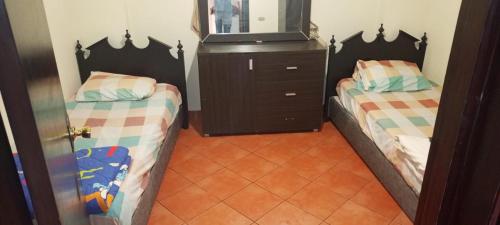 a bedroom with two beds and a dresser with a mirror at Pyramids Porto Sokhna Hotel Apartments in Ain Sokhna