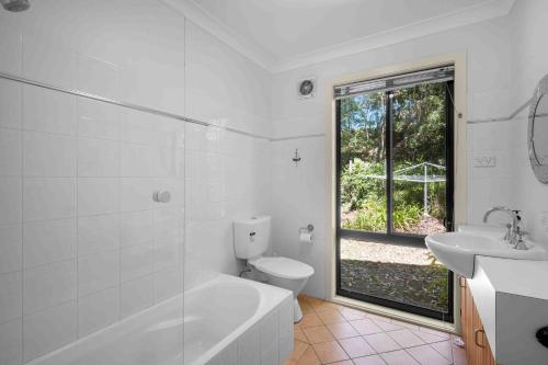 a bathroom with a tub and a toilet and a sink at Amazing Views - Belle Escapes Jervis Bay in Vincentia