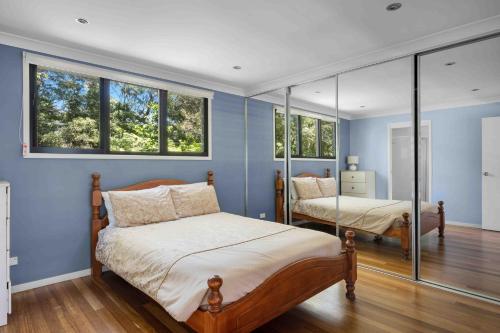 a bedroom with two beds and two windows at Amazing Views - Belle Escapes Jervis Bay in Vincentia