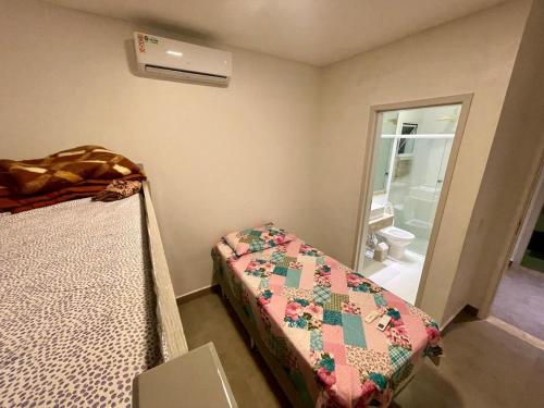 a small bedroom with a bed and a window at Mansão Maretti in Bertioga