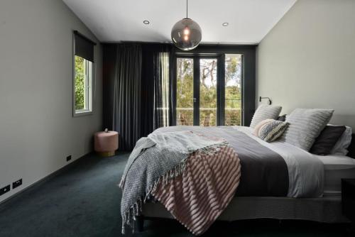 a bedroom with a large bed and a window at Romantic Lakefront Luxury - Spa Bath, Fireplace, King Bed in Daylesford