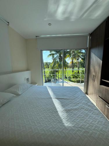 um quarto com uma cama e uma porta de vidro deslizante em Condominio El Peñon, Girardot em El Peñón