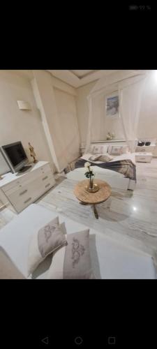 a bedroom with two beds and a table and a tv at guiliz in Marrakech