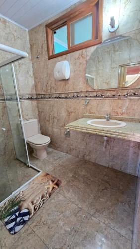 um banheiro com vaso sanitário, pia e espelho em Almar Hospedagem 2 ARRAIAL DO CABO em Arraial do Cabo