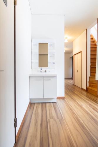 a bathroom with a sink and a wooden floor at 勝山駅徒歩1分 恐竜博物館車5分スキージャム15分 BBQ可能 シアタールーム Kidsルーム完備 駅前好立地 in Katsuyama