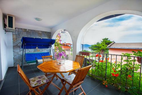 a patio with a wooden table and chairs on a balcony at Apartments Pines in Bar