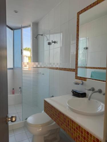 um banheiro com vaso sanitário, pia e chuveiro em Condominio El Peñon, Girardot em El Peñón