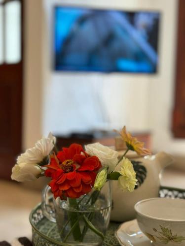 a vase with red and white flowers on a table at Casa37 in Buenos Aires