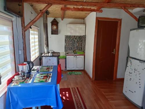 una cucina con tavolo blu in una camera di Cabaña carmen velasquez a Calbuco